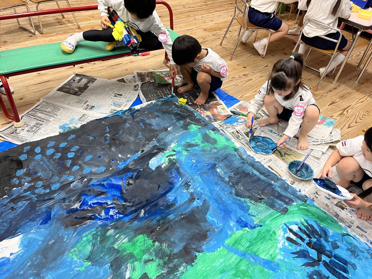 Children painting the ocean mural together