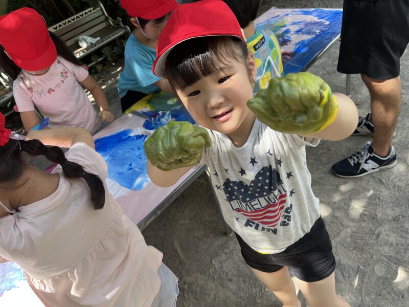 Child showing paint-covered hands